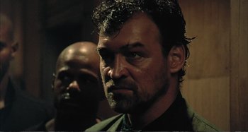 Movie still from “Red Heat” (1988), directed by Walter Hill – A person wearing a suit and tie; Close Up shot, Low angle