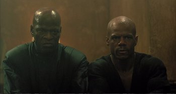 Movie still from “Red Heat” (1988), directed by Walter Hill – A couple of men standing next to each other; Close Up shot, Low angle