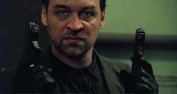 Movie still from “Red Heat” (1988), directed by Walter Hill – A person holding a gun; Close Up shot, Low angle