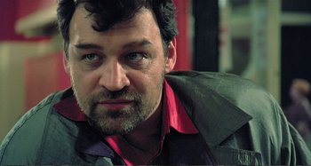 Movie still from “Red Heat” (1988), directed by Walter Hill – A person wearing a jacket; Close Up shot, Over the shoulder angle