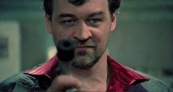 Movie still from “Red Heat” (1988), directed by Walter Hill – A person holding a gun; Close Up shot, Low angle