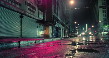 Movie still from “Red Heat” (1988), directed by Walter Hill – A city street at night lit by street lights; Wide shot, High angle