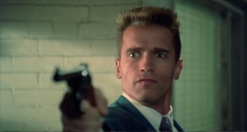 Movie still from “Red Heat” (1988), directed by Walter Hill – A person holding a gun in a room; Close Up shot, Low angle