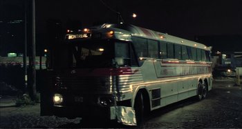 Movie still from “Red Heat” (1988), directed by Walter Hill – A city bus driving down a street at night; Wide shot, High angle