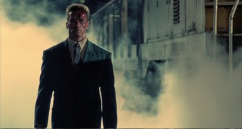 Movie still from “Red Heat” (1988), directed by Walter Hill – A man in a suit and tie with a blood on his face; Wide shot, Low angle