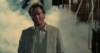 Movie still from “Red Heat” (1988), directed by Walter Hill – A man in a gray jacket and a white shirt; Close Up shot, Low angle