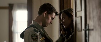 Movie still from “Red Hill” (2010), directed by Patrick Hughes – A man and a woman standing next to each other in front of a wall; Close Up shot, Over the shoulder angle