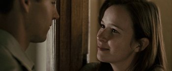 Movie still from “Red Hill” (2010), directed by Patrick Hughes – A woman smiles at the camera as a man looks on; Close Up shot, Over the shoulder angle