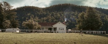 Movie still from “Red Hill” (2010), directed by Patrick Hughes – An old white house in the middle of a field; Extreme Wide shot, High angle