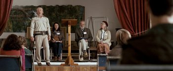 Movie still from “Red Hill” (2010), directed by Patrick Hughes – A group of people sitting in front of a microphone; Wide shot, High angle