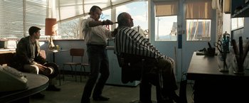 Movie still from “Red Hill” (2010), directed by Patrick Hughes – A man getting his hair cut at a barber shop; Medium shot, Over the shoulder angle