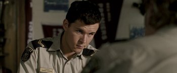 Movie still from “Red Hill” (2010), directed by Patrick Hughes – A man in a uniform looking at a camera; Close Up shot, High angle