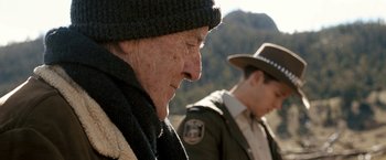 Movie still from “Red Hill” (2010), directed by Patrick Hughes – A man wearing a hat and a scarf and another man wearing a jacket and a hat; Close Up shot, Over the shoulder angle