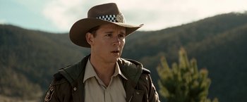 Movie still from “Red Hill” (2010), directed by Patrick Hughes – A man wearing a hat standing in front of a mountain range; Close Up shot, Over the shoulder angle