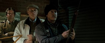 Movie still from “Red Hill” (2010), directed by Patrick Hughes – A man holding a rifle while standing next to another man; Medium shot, Low angle