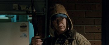 Movie still from “Red Hill” (2010), directed by Patrick Hughes – A man with a hat on holding a rifle; Close Up shot, Over the shoulder angle