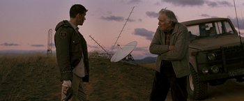 Movie still from “Red Hill” (2010), directed by Patrick Hughes – Two men standing in a field with a satellite dish in the background; Medium shot, Over the shoulder angle