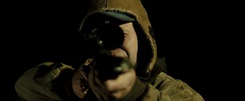 Movie still from “Red Hill” (2010), directed by Patrick Hughes – A man in a hooded jacket is holding a gun; Extreme Close Up shot, Low angle