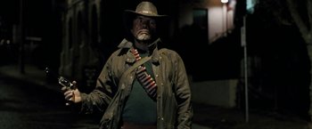 Movie still from “Red Hill” (2010), directed by Patrick Hughes – A man wearing a hat and a tie; Medium shot, Over the shoulder angle