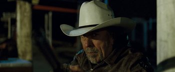 Movie still from “Red Hill” (2010), directed by Patrick Hughes – A man in a white cowboy hat is looking at the camera; Close Up shot, Over the shoulder angle