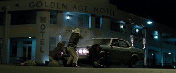 Movie still from “Red Hill” (2010), directed by Patrick Hughes – A group of men standing next to a car; Wide shot, Low angle