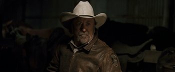 Movie still from “Red Hill” (2010), directed by Patrick Hughes – A man wearing a cowboy hat and a leather jacket; Close Up shot, Over the shoulder angle