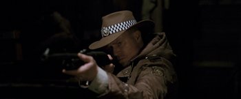 Movie still from “Red Hill” (2010), directed by Patrick Hughes – A man wearing a hat and holding a gun; Close Up shot, Over the shoulder angle