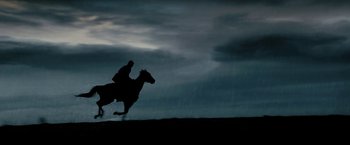 Movie still from “Red Hill” (2010), directed by Patrick Hughes – A person riding a horse in the dark; Wide shot, Low angle
