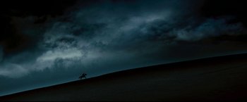Movie still from “Red Hill” (2010), directed by Patrick Hughes – A horse is running on a hill under a cloudy sky; Extreme Wide shot, Low angle