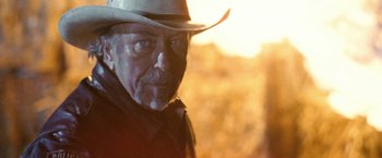 Movie still from “Red Hill” (2010), directed by Patrick Hughes – An older man wearing a cowboy hat in a field; Close Up shot, Over the shoulder angle