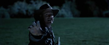 Movie still from “Red Hill” (2010), directed by Patrick Hughes – A man in a cowboy hat is holding a gun; Close Up shot, Over the shoulder angle