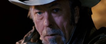 Movie still from “Red Hill” (2010), directed by Patrick Hughes – An older man with a gray beard wearing a white hat; Extreme Close Up shot, Over the shoulder angle