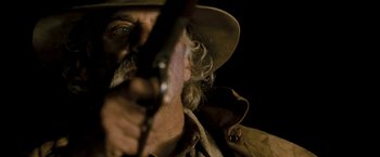 Movie still from “Red Hill” (2010), directed by Patrick Hughes – A person holding a gun; Close Up shot, Over the shoulder angle