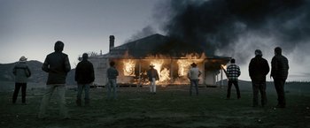 Movie still from “Red Hill” (2010), directed by Patrick Hughes – Three people standing in front of a burning house; Wide shot, Low angle