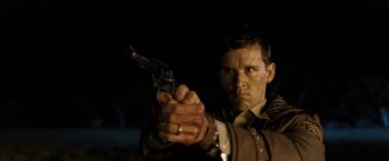 Movie still from “Red Hill” (2010), directed by Patrick Hughes – A man holding a gun with blood on his face; Close Up shot, Low angle