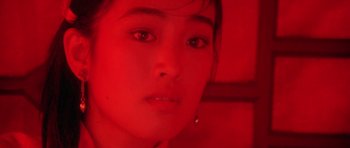 Movie still from “Red Sorghum” (1988), directed by Yimou Zhang – A woman's face in a red light; Close Up shot, High angle