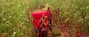 Movie still from “Red Sorghum” (1988), directed by Yimou Zhang – A group of people walking through a field; Wide shot, High angle