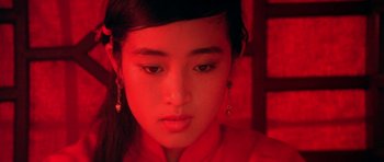 Movie still from “Red Sorghum” (1988), directed by Yimou Zhang – A young woman with long black hair wearing a red dress; Close Up shot, High angle