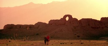 Movie still from “Red Sorghum” (1988), directed by Yimou Zhang – Two people on a horse in the desert at sunset; Extreme Wide shot, Low angle