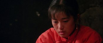 Movie still from “Red Sorghum” (1988), directed by Yimou Zhang – A woman in a red shirt is looking down; Close Up shot, High angle