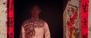 Movie still from “Red Sorghum” (1988), directed by Yimou Zhang – A man standing in front of a wall with shadows on the wall; Medium shot, Low angle