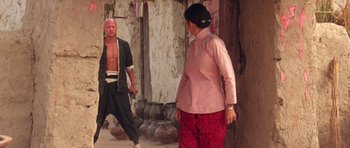 Movie still from “Red Sorghum” (1988), directed by Yimou Zhang – A man and a woman are standing next to each other; Wide shot, Over the shoulder angle