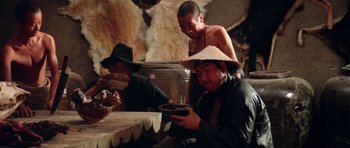 Movie still from “Red Sorghum” (1988), directed by Yimou Zhang – A group of men sitting around a table eating food; Medium shot, High angle