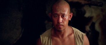 Movie still from “Red Sorghum” (1988), directed by Yimou Zhang – A man with a shaved head and a white shirt; Close Up shot, Low angle