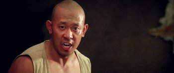 Movie still from “Red Sorghum” (1988), directed by Yimou Zhang – A man with a shaved head and a bald head; Close Up shot, Low angle