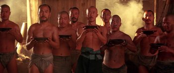 Movie still from “Red Sorghum” (1988), directed by Yimou Zhang – A group of men standing next to each other holding bowls; Medium shot, Low angle