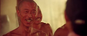 Movie still from “Red Sorghum” (1988), directed by Yimou Zhang – A group of shirtless men standing next to each other in a room; Close Up shot, Low angle