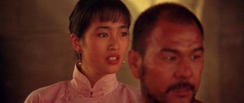 Movie still from “Red Sorghum” (1988), directed by Yimou Zhang – A young woman in a pink shirt is looking at a man in a pink shirt; Close Up shot, Over the shoulder angle
