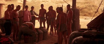 Movie still from “Red Sorghum” (1988), directed by Yimou Zhang – A group of men standing around in the dirt; Wide shot, High angle