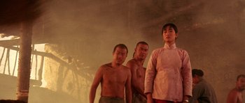 Movie still from “Red Sorghum” (1988), directed by Yimou Zhang – A group of men standing next to each other in a room; Medium shot, Low angle
